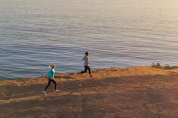 women running along coastal bluffs