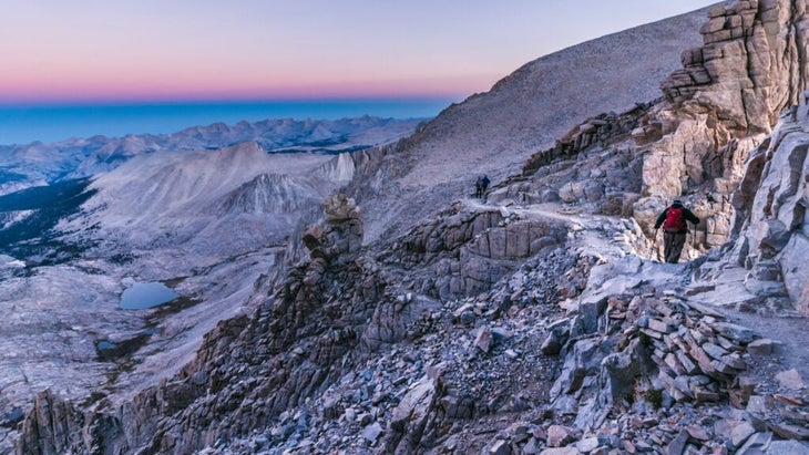 Dawn breaks over Sequoia National Park and sees hikers already en route to the summit of Mount Whitney.