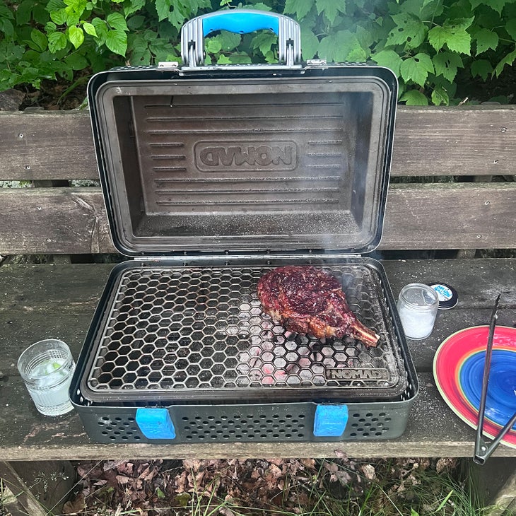 Nomad Grill in use on wooden bench