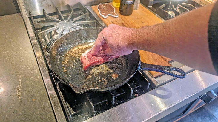Wes Siler cooking steak in butter and olive oil in a cast iron skillet
