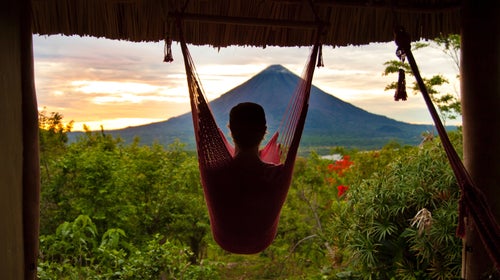 A man sits in a hammock looking out at Concepción volcano in Nicaragua.