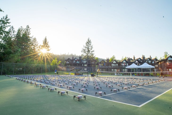 Hundreds of drones laid out on a tennis court in preparation for a fireworks show