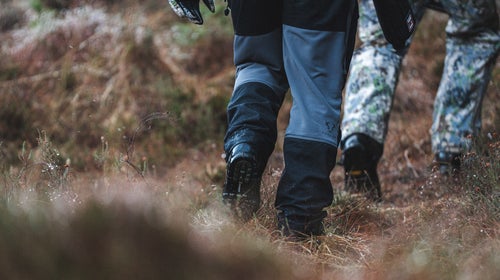 hunters walk through a field in Scotland