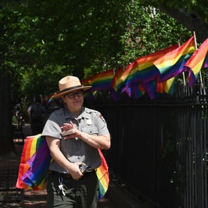 A park ranger places rainbow flags at the Stonewall National Monument on June 4, 2019 in New York City.