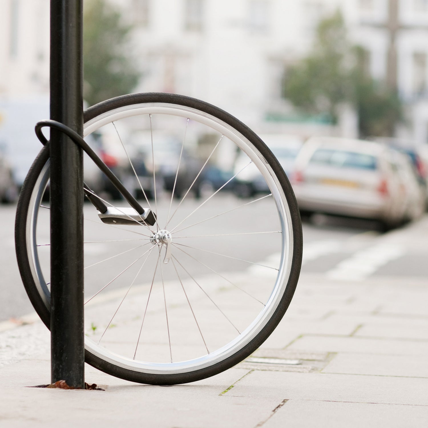 Bike wheel with lock attached to lamp post on street after bike stolen