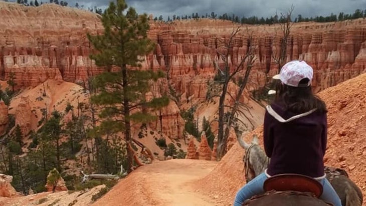 A girl sits on a mule as it wends along a trail through Utah’s Bryce Canyon National Park.