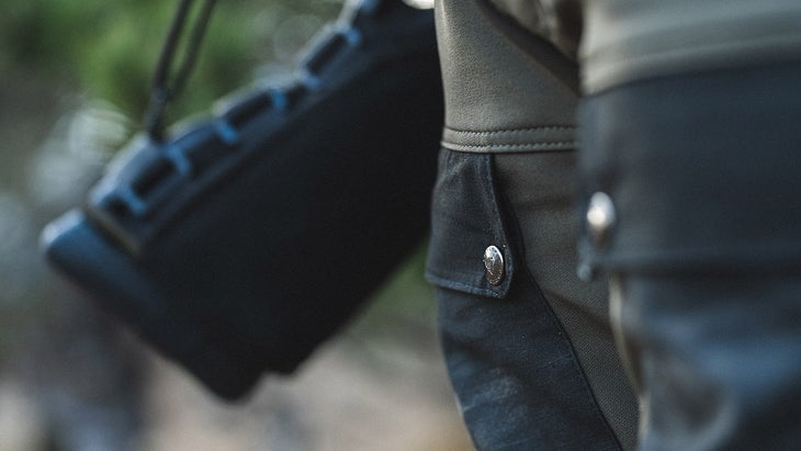 hunter stands with a rifle, shot of thigh pockets of hunting pants