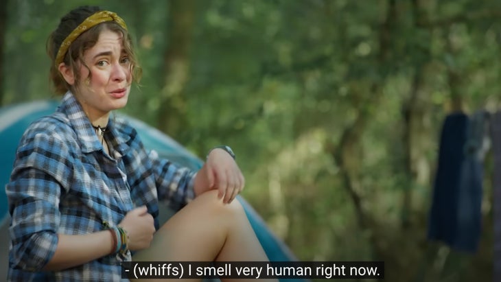 Screenshot of a woman wearing a flannel shirt and saying, "I smell very human right now."