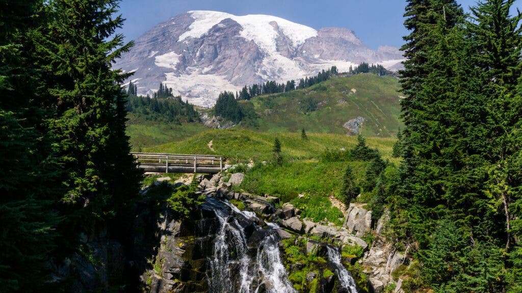 Myrtle Falls, backed by a snowcapped Mount Rainer in summer.