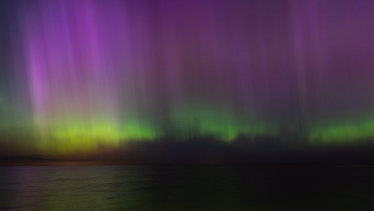 Watercolor-like lights in electric purple and green brush the night sky from Lake Erie near Cleveland. 