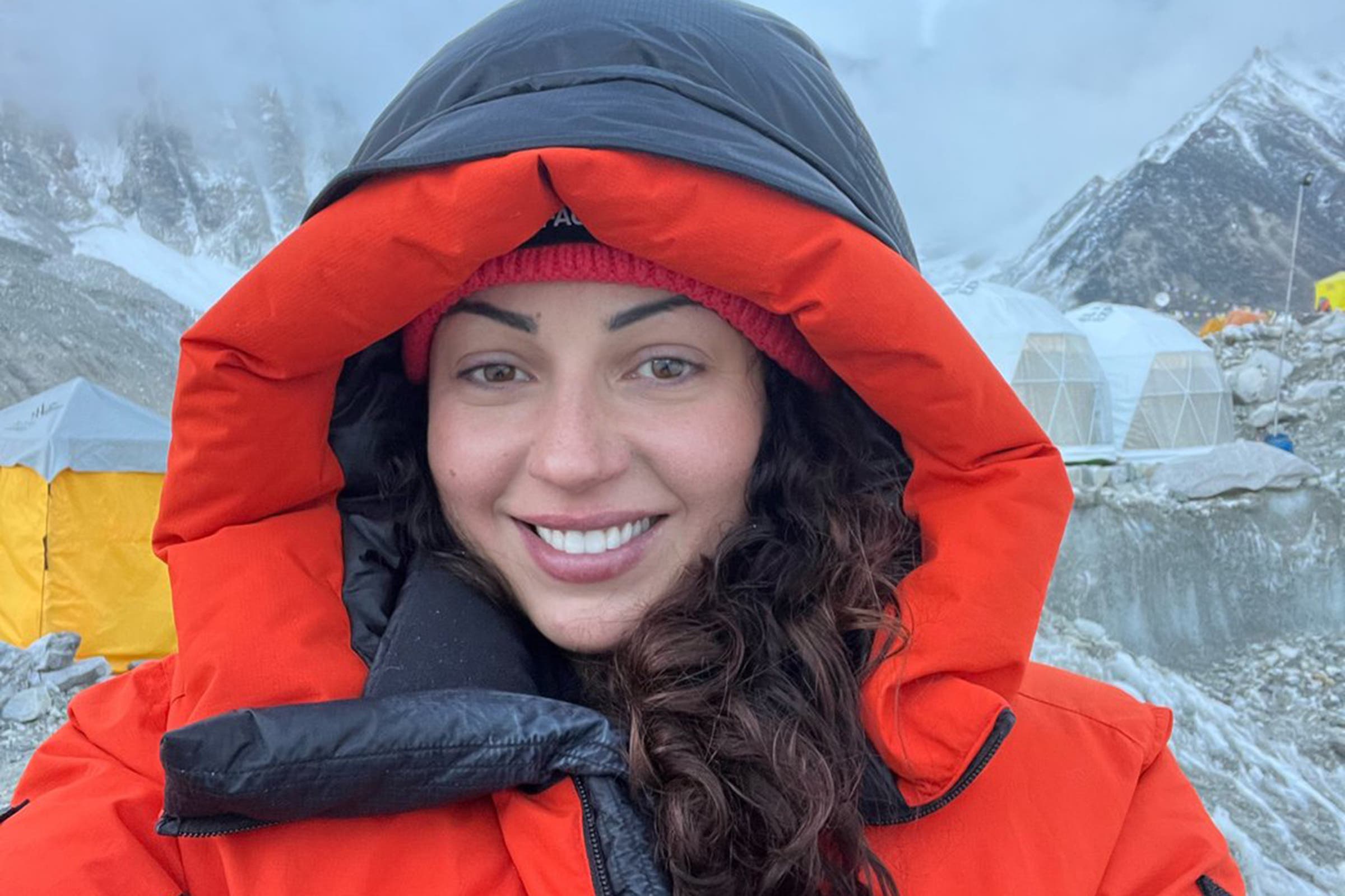 A woman in a large jacket smiles at the camera