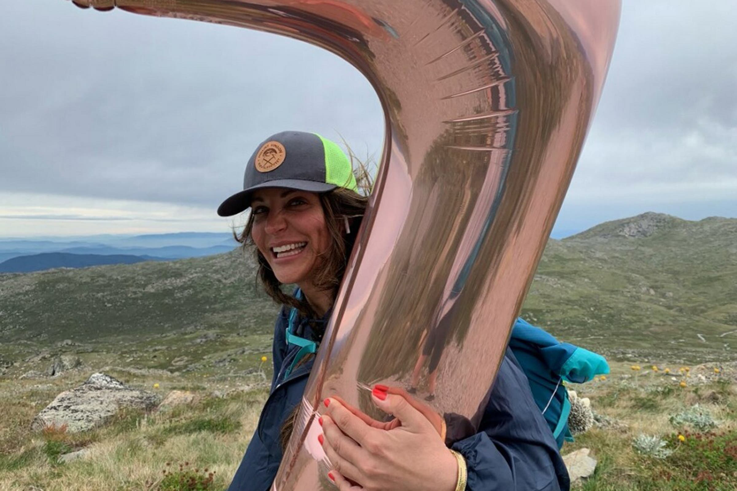A woman holding a balloon on top of a mountain