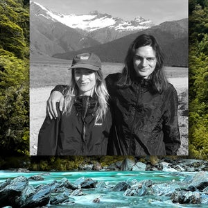 An image of a man and woman smiling in front of mountains superimposed upon a photograph of a forest