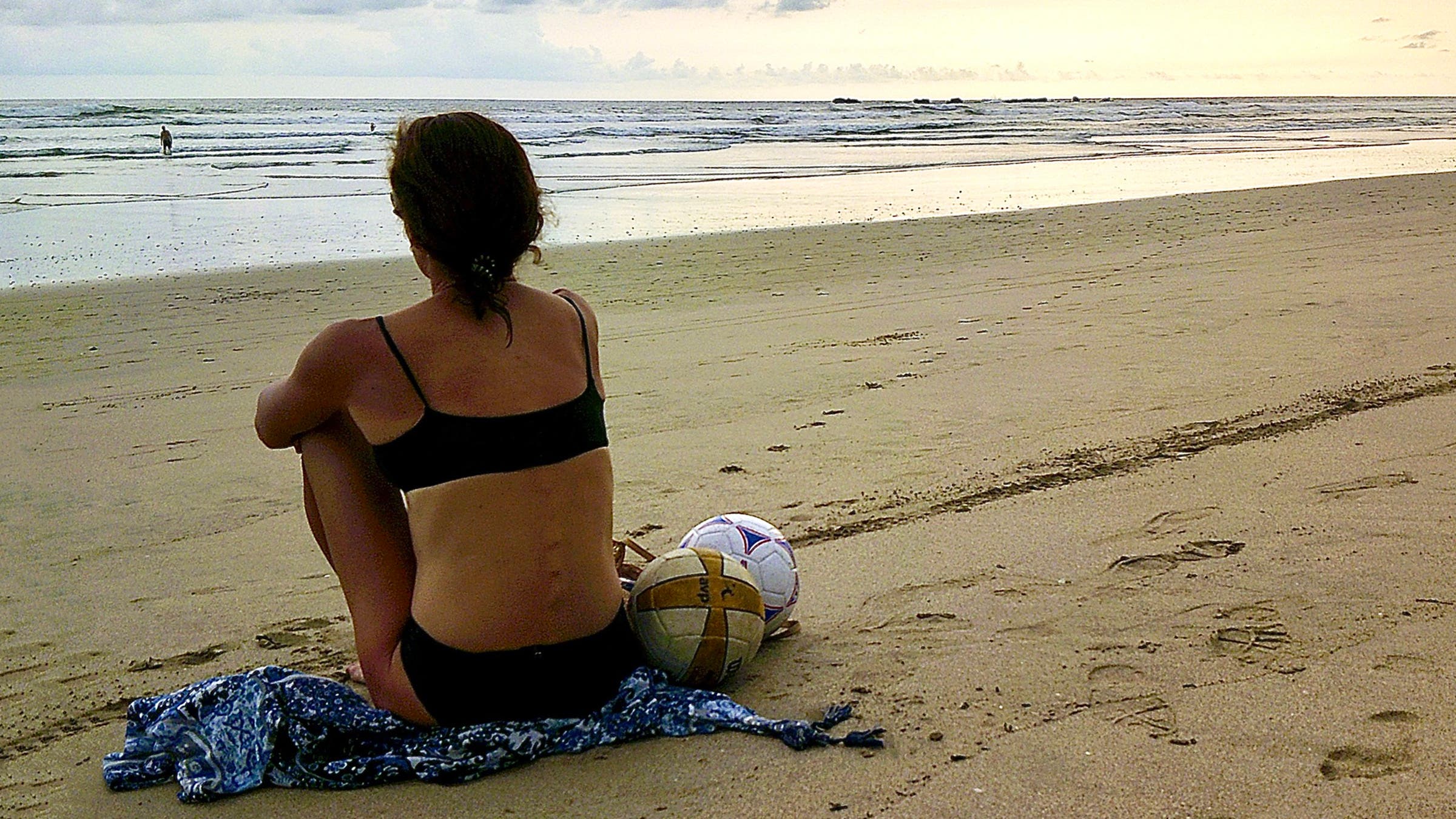 woman sitting on a beach in a bikini