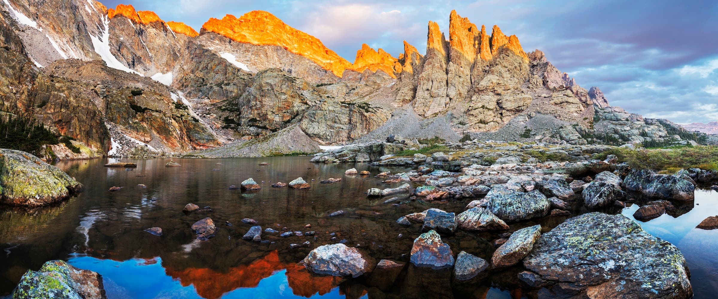 Photograph capturing Alpenglow on the sharks teeth above Rocky Mountain National Park Sky Pond