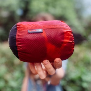 a small red stuff sack containing a sleeping bag liner