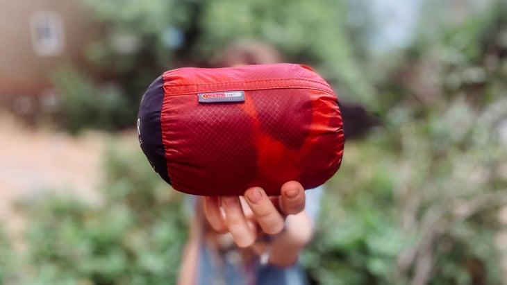 a small red stuff sack containing a sleeping bag liner