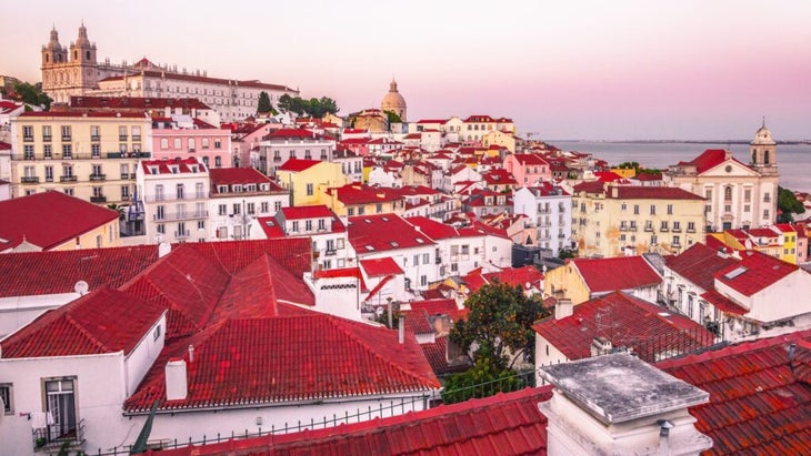 The red-roofed homes and cathedral in the historic Alfama district of Lisbon, Portugal.