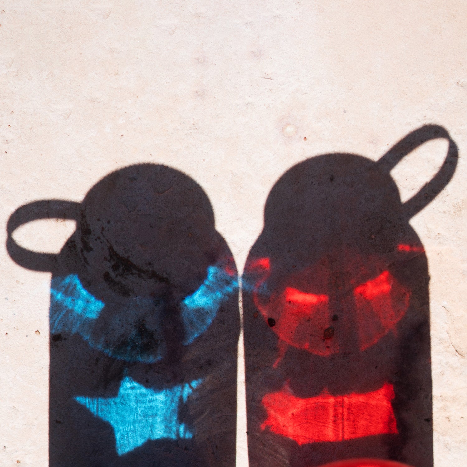 Photo of two nalgene bottles with the reflection of a flag—one is red, one is blue