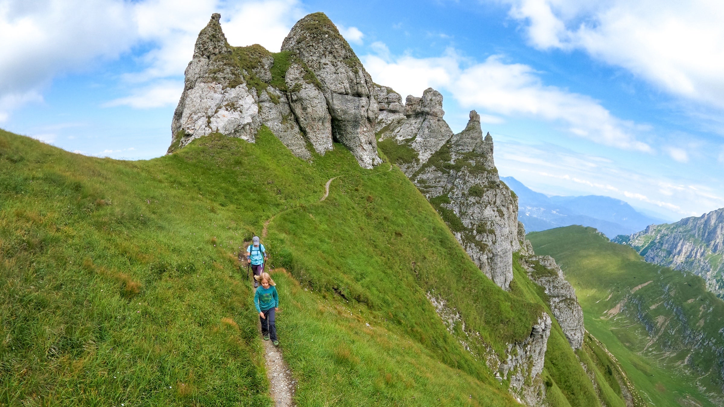 A mother and child wend down the trail high atop central Romania’s steep, green Bucegi Mountains.
