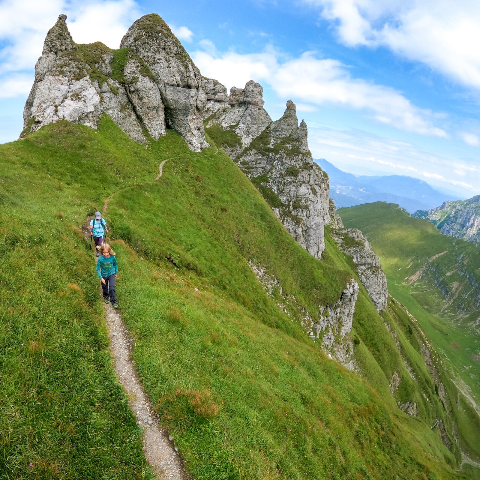 A mother and child wend down the trail high atop central Romania’s steep, green Bucegi Mountains.