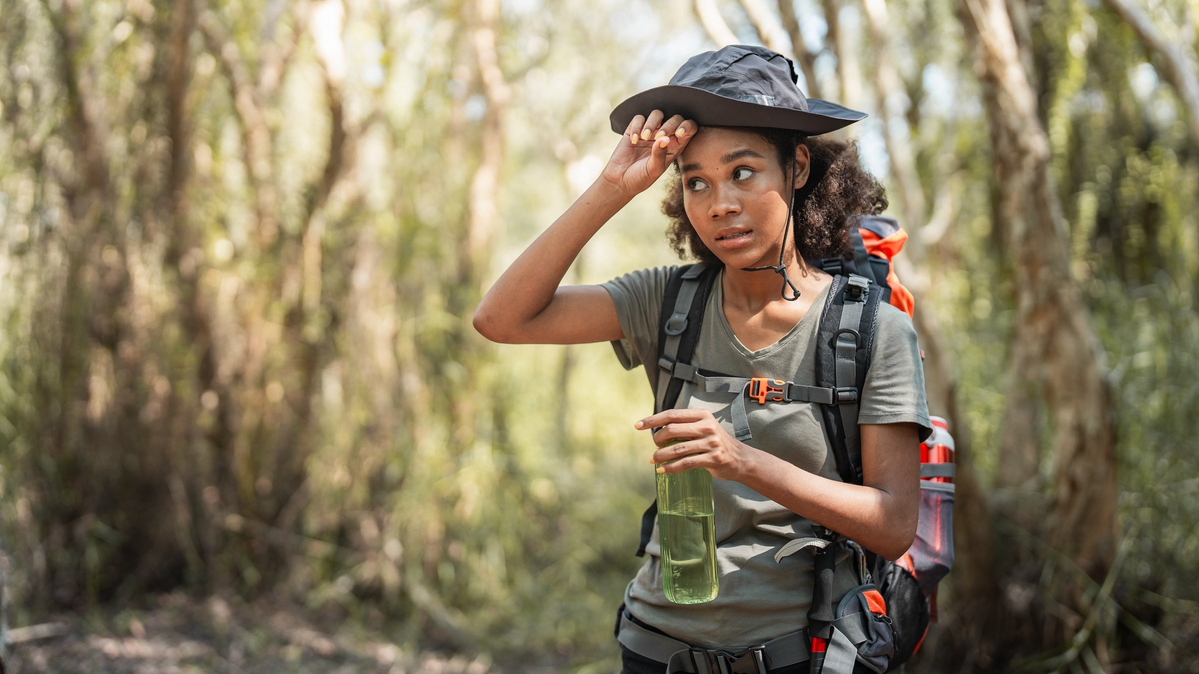 A woman in the forest hiking in the heat