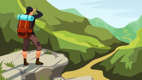 A man stands on cliff top overlooking hiking trail