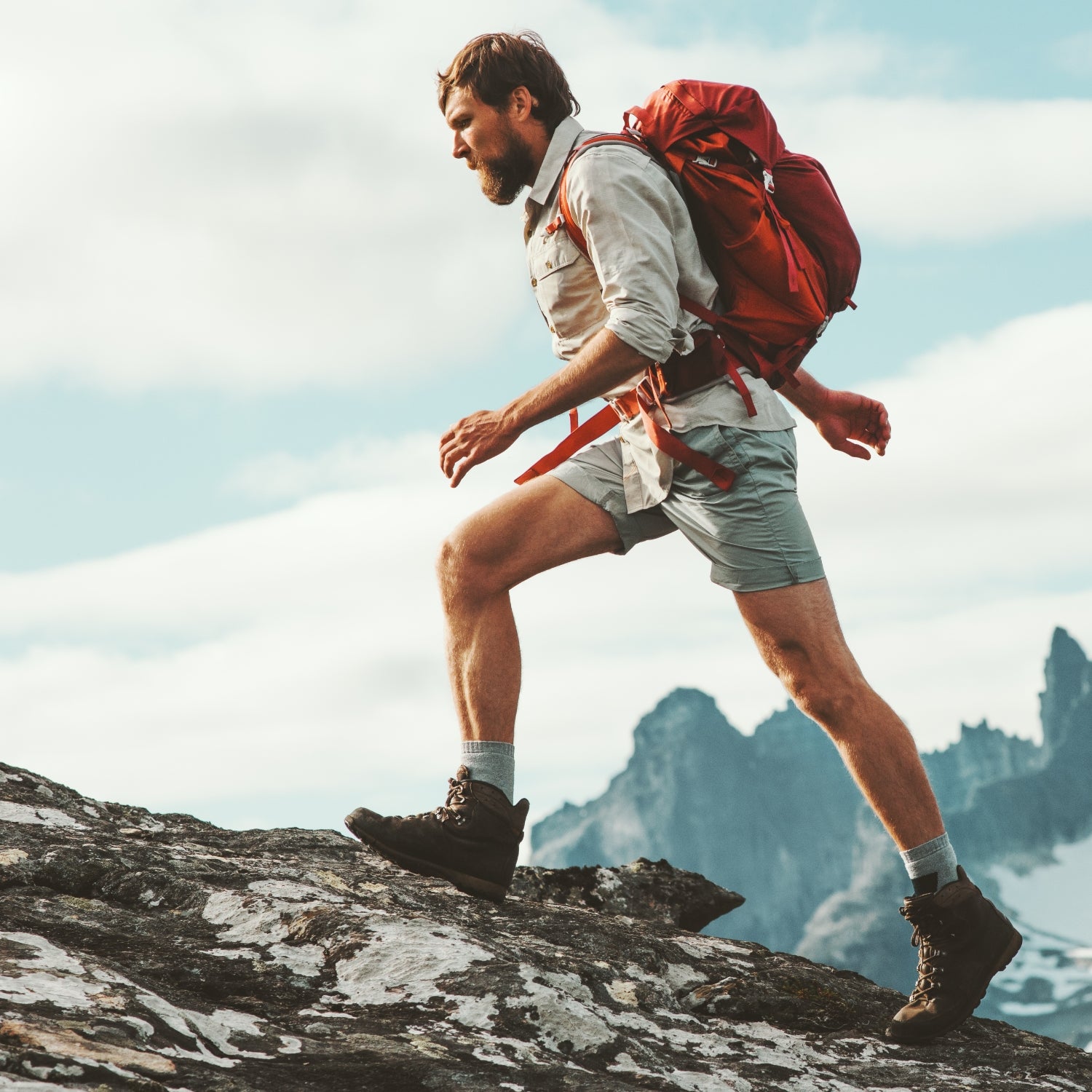 Man rucking in mountains with weighted backpack.