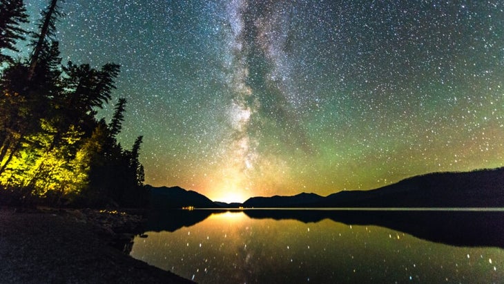 The Milky Way is reflected in the waters of Glacier National Park’s Lake Macdonald.