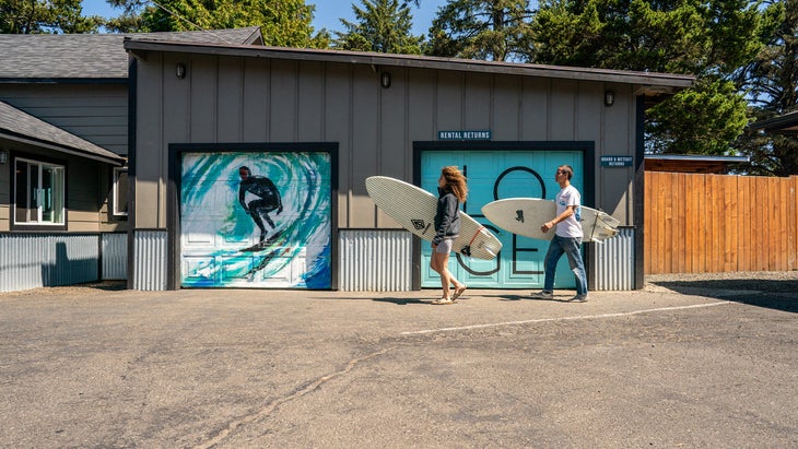 two surfers carry their boards at the end of the day in Westport.