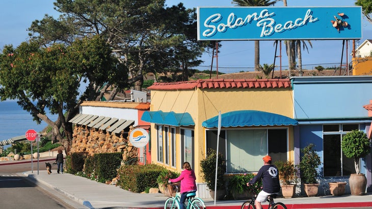 two people bike around town in Solana Beach