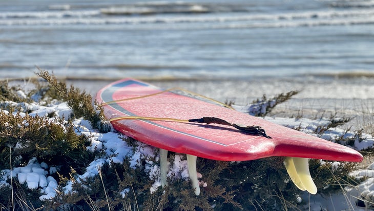 surfboard in the snow on edge of Lake Michigan