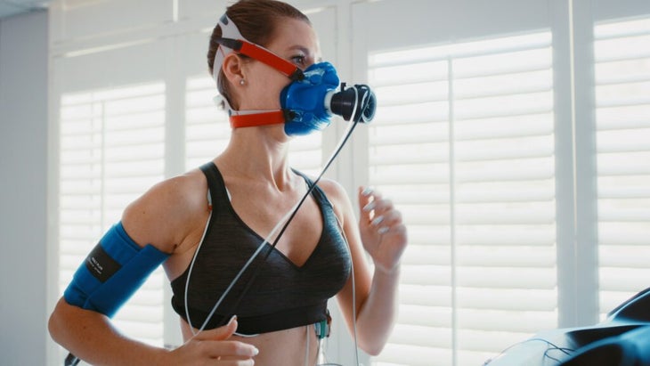 Vo2 max training mask with a young athlete exercising for fitness during a workout at the physio to monitor her health and wellness.