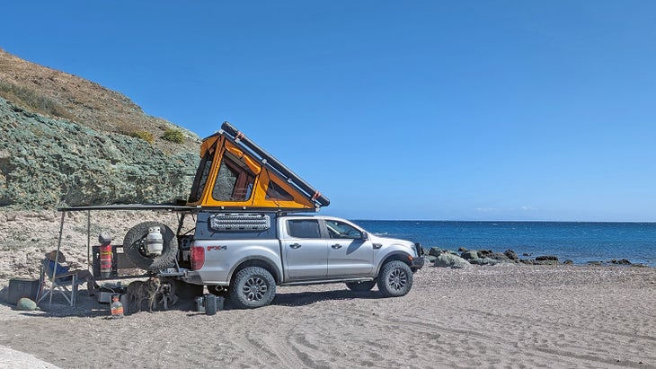 A truck camper parked on a beach