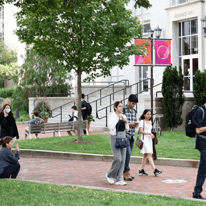 College campus with students walking across the lawn and the brick paths