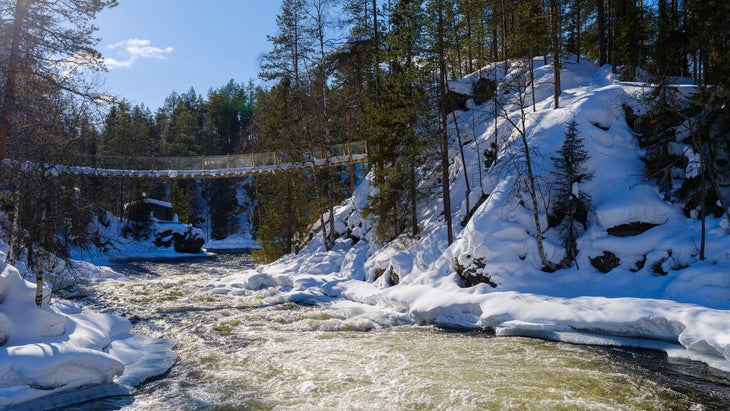 snow covered suspension bridge over the River Kitkajoki, Finland