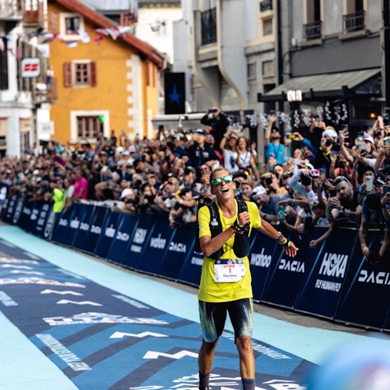 woman finishing race in yellow smiling