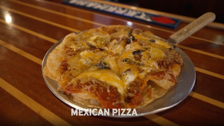 closeup of a pizza on a wooden bar