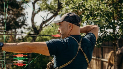 Attia aiming a bow and arrow