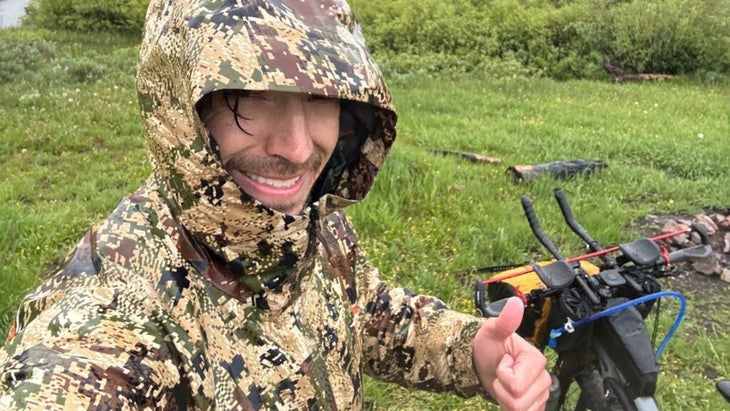 man with hooded jacket giving a thumbs up in the rain