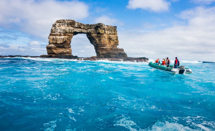 Tourists on a Zodiac crossing the Pacific to shoot photos of the stone Darwin Arch in the Galapagos Islands before it toppled a few years ago.