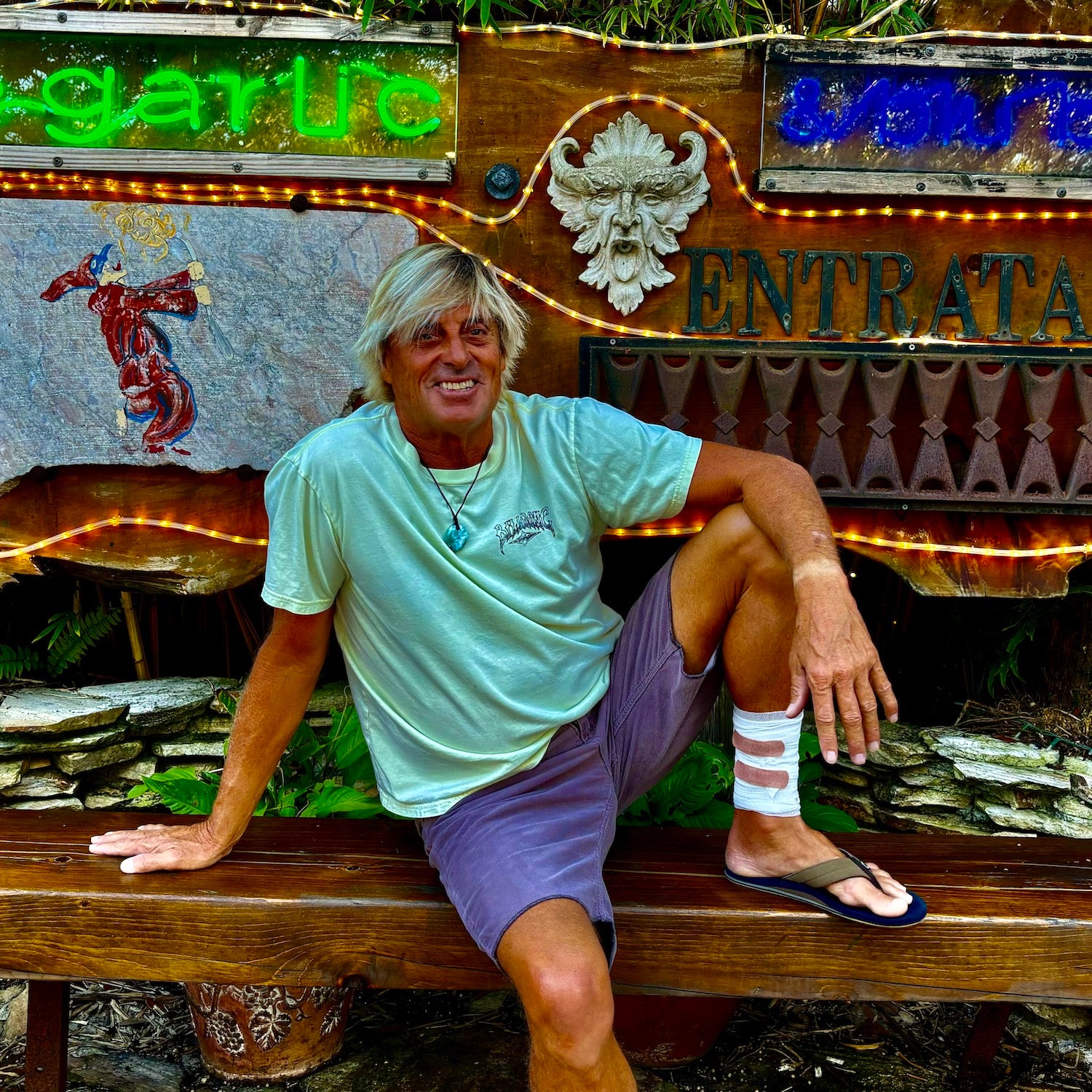 Charley Hajek sitting on a bench with a bandage on his leg