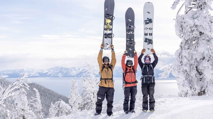 Splitboarders holding up their boards in the snow