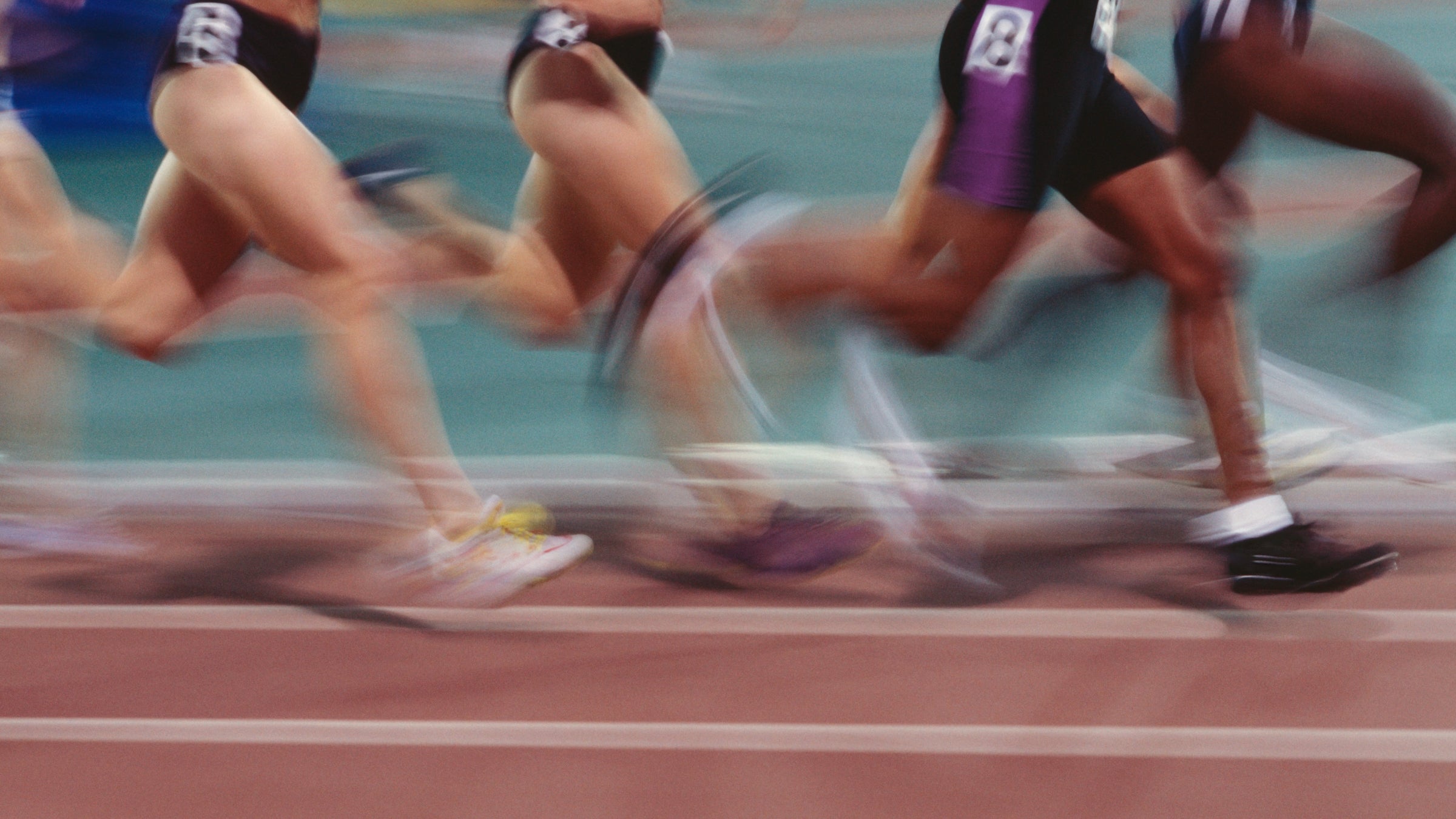 blurred image of women track runners in long distance race