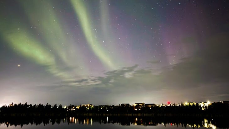 Green, pink, and purple northern lights shine over Niven Lake in the Northern Territories’ city of Yellowknife.