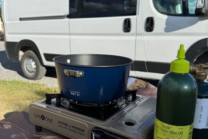 simple propane stove with a pot sitting outside a Wayfarer camper van 