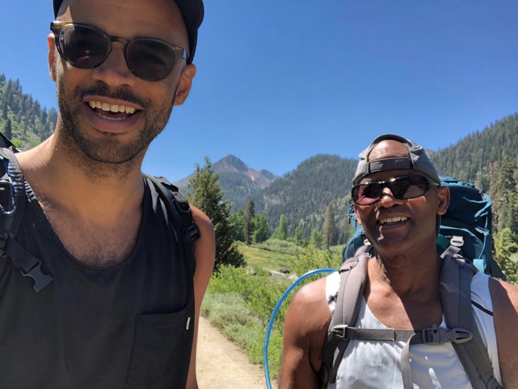 dad and son selfie on trail with blue sky and big smiles