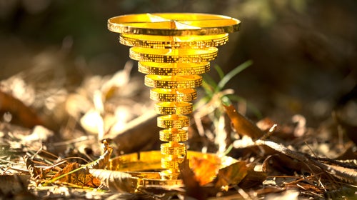a tornado-shaped gold object on the forest floor