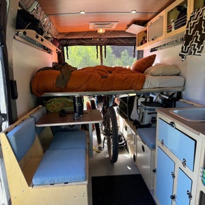 The interior of a van with blue cabinets and an open window