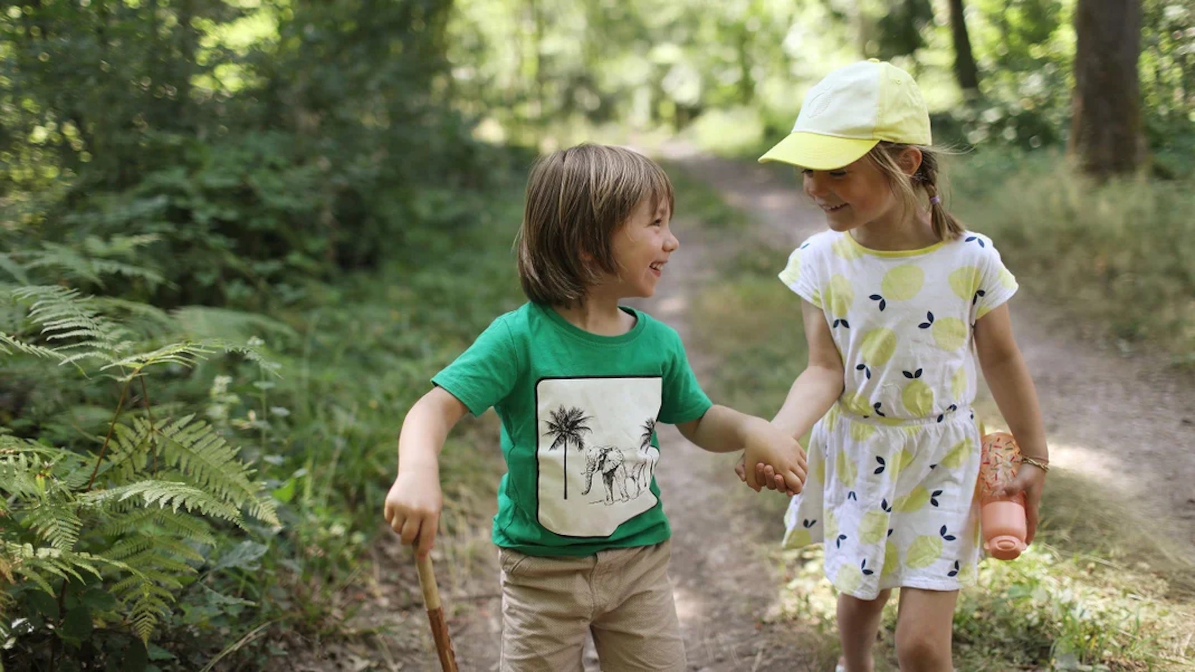 two kids holding hands on a trail